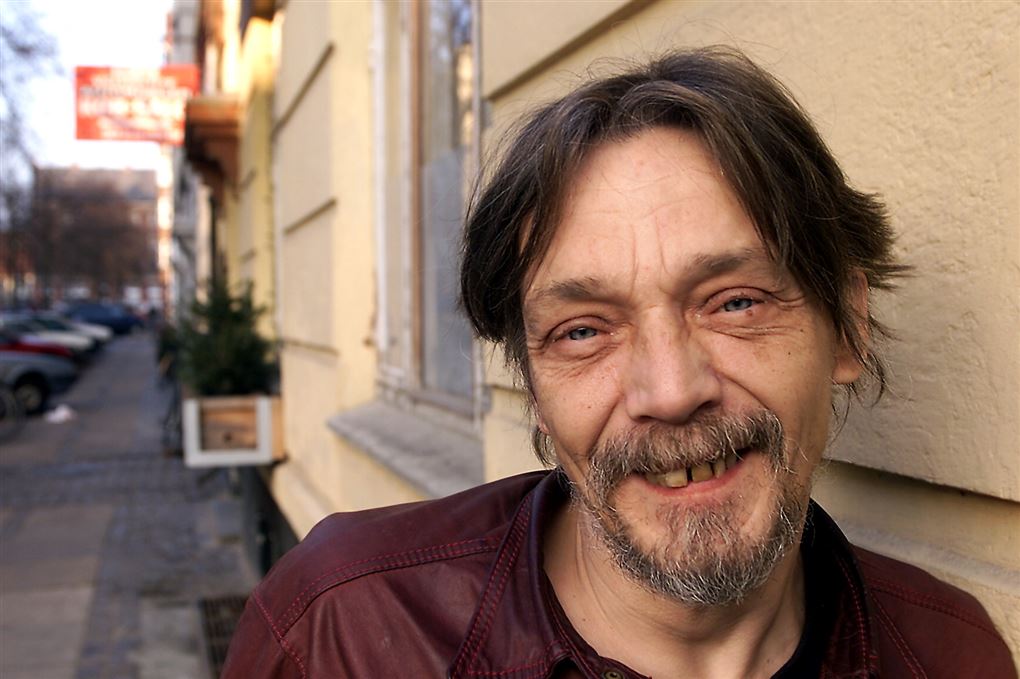 en mand smiler til fotografen