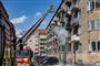 Brandbil med stige uden for en etageejendom i brand
