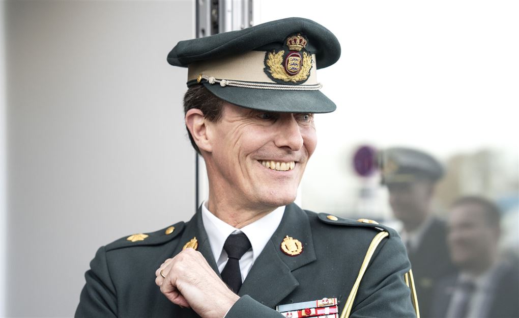 en prins i uniform smiler bredt