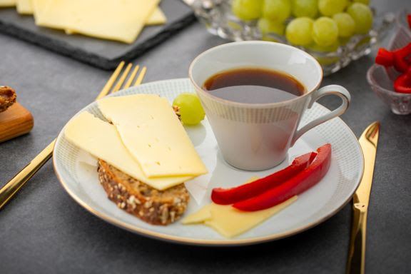 tallerken med kaffe, ost og rød peber